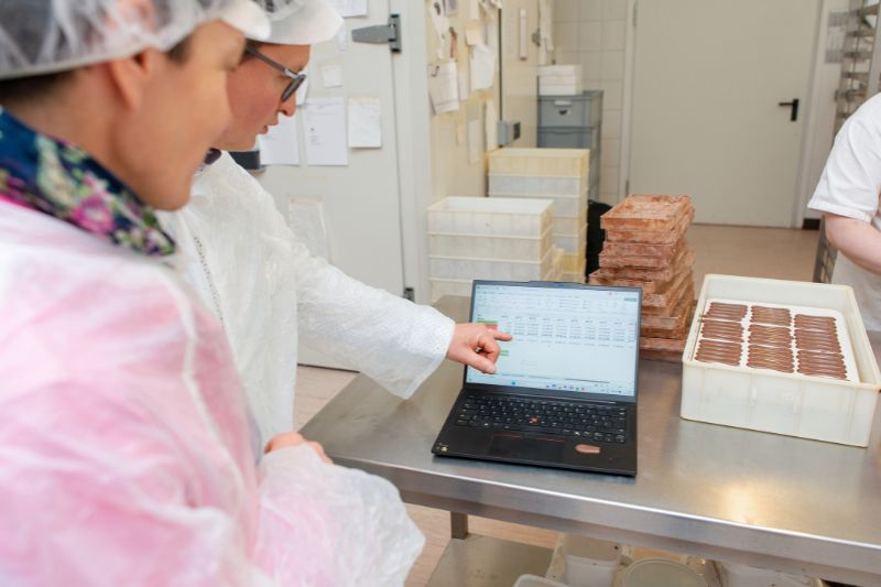 Hände am Tisch beim Notieren – konkrete Arbeit an einer Mappe als Sinnbild für strukturierte Begleitung durch RE-Consult